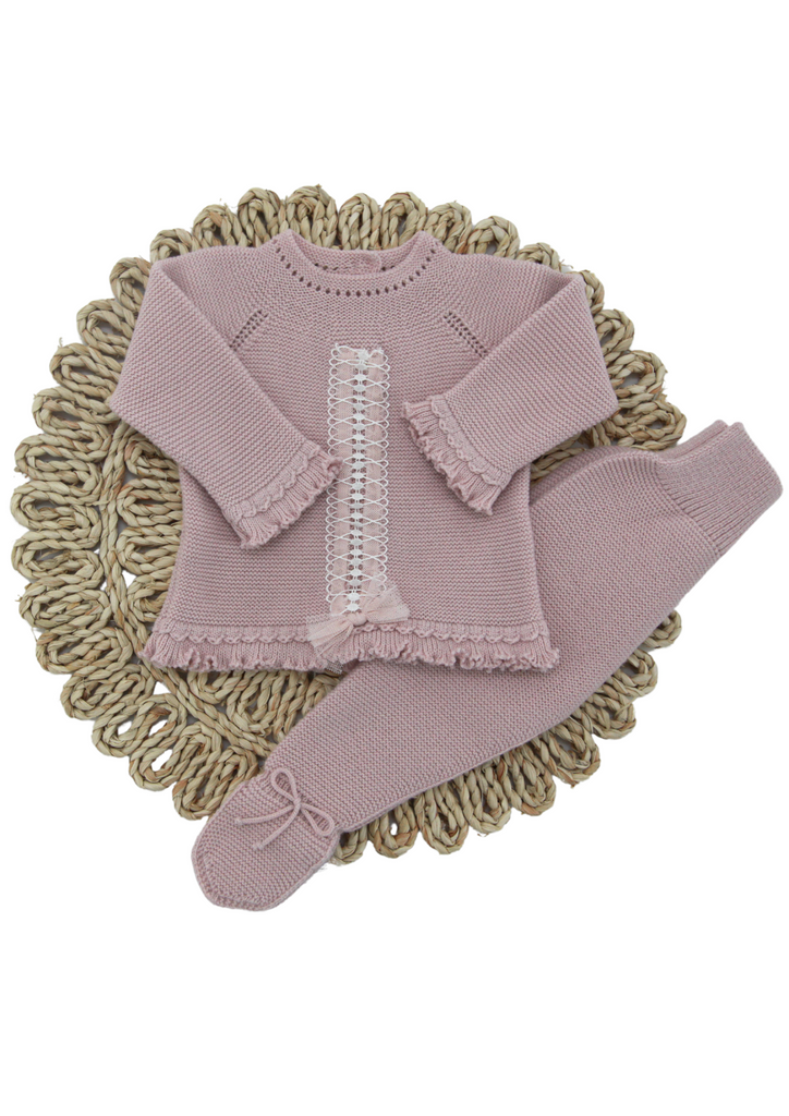 Pink and grey knitted two-piece set for newborn girls from Artesania Granlei. The beautiful top has an elegant ruffle hem and a pink and white embroidered detail down the front with a tulle bow. The pants have a  delicate bow on each foot.
